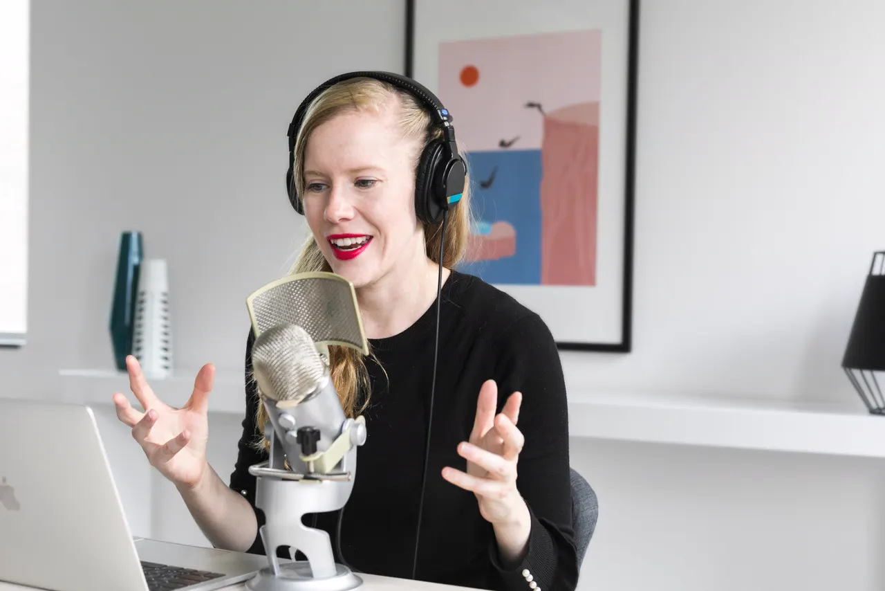 A woman recording a show at her microphone