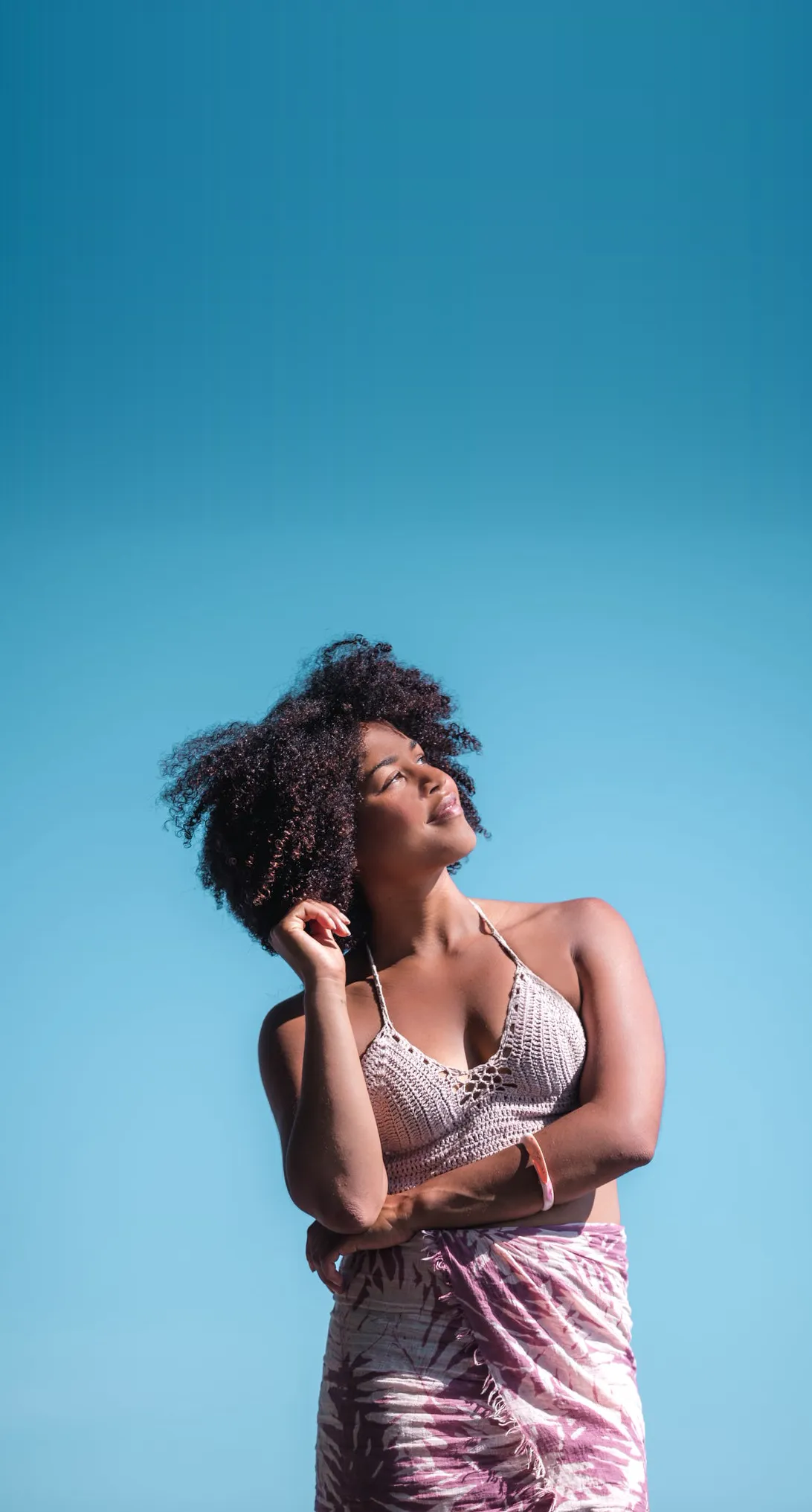 A woman in the sun under a blue sky